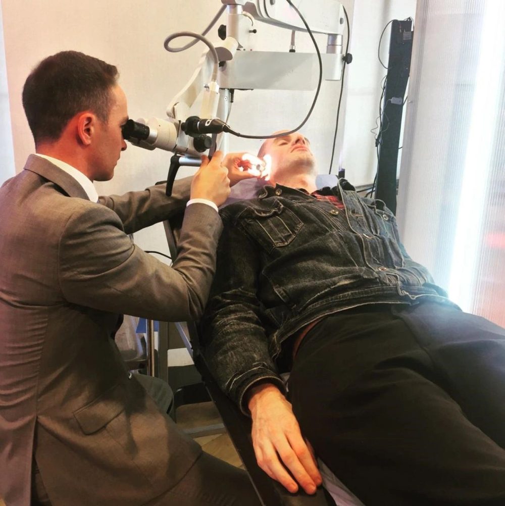 Raúl García-Medina performing aural micro-suction on a patient using an ENT surgical microscope